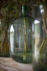 Цветы в прозрачной зеленой стеклянной вазе — стоковое фото