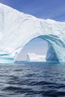 Велична айсбергова арка над сонячним блакитним Атлантичним океаном Гренландія — стокове фото