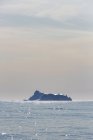 Iceberg in distance on sunny tranquil Atlantic Ocean Greenland — Stock Photo