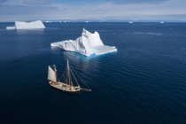 Ship sailing past majestic icebergs on sunny blue Atlantic Ocean Greenland — Stock Photo