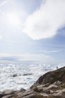 Personne sur une falaise surplombant la fonte ensoleillée de la glace glaciaire Groenland — Photo de stock