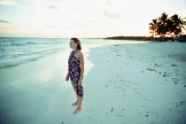 Беззаботная женщина в солнечном платье на спокойном океанском пляже Мексики — стоковое фото