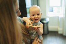 Portrait cute baby girl in mother arms - foto de stock