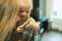 Mãe segurando bonito bebê menina com brinquedo — Fotografia de Stock