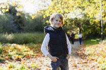 Retrato de niño confiado en el soleado parque de otoño - foto de stock