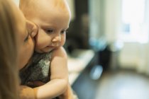 Close up mother kissing cute baby daughter — Stock Photo