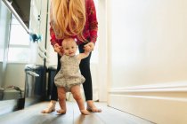 Ritratto madre aiutare bambino figlia camminare in corridoio — Foto stock