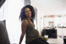 Portrait happy young pregnant woman drinking green smoothie — Stock Photo