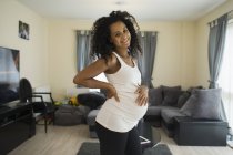 Portrait happy young pregnant woman in living room — Stock Photo