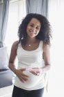 Portrait confiant jeune femme enceinte prenant des vitamines — Photo de stock