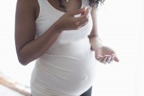 Close up grávida jovem tomando vitaminas pré-natais — Fotografia de Stock