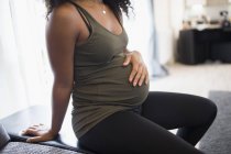 Pregnant woman holding stomach — Stock Photo