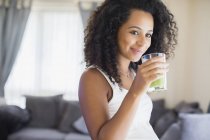 Счастливая беременная женщина пьет зеленый смузи — стоковое фото