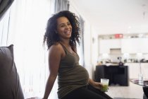 Happy young pregnant woman drinking green smoothie — Stock Photo
