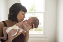 Affectionate mother holding newborn baby son — Stock Photo