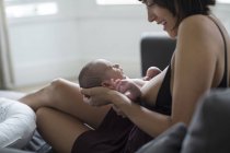 Мать держит и кормит грудью новорожденного сына — стоковое фото