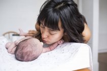 Mother kissing newborn baby son — Stock Photo