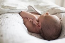 Закройте новорожденного мальчика, лежащего в колыбели — стоковое фото