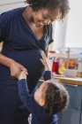 Neugierige Tochter berührt schwangeren Mutterbauch — Stockfoto