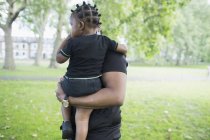 Pai segurando filho criança no parque — Fotografia de Stock