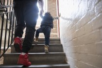Батько допомагає маленькому синові підніматися сходами — стокове фото