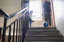 Pai e filho criança brincando com bola de futebol no desembarque escada — Fotografia de Stock