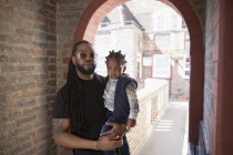 Portrait father holding toddler son in corridor archway — Stock Photo
