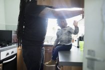 Padre e hijo menor en la cocina de apartamentos. - foto de stock