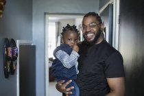 Portrait happy father holding toddler son — Stock Photo