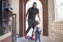 Padre e bambino figlio giocare con palla di calcio in corridoio — Foto stock