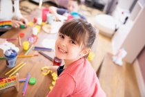 Portrait happy enthusiastic girl playing with toys at table — Stock Photo