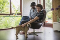 Щаслива молода пара з собакою в домашньому офісі — стокове фото