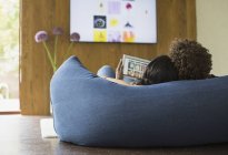 Giovani coppie rilassanti foto in streaming dal tablet digitale alla TV — Foto stock