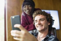 Jovens felizes casal multiétnico vídeo conversando com telefone inteligente — Fotografia de Stock