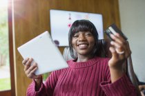 Portrait heureuse jeune femme achats en ligne avec tablette numérique — Photo de stock