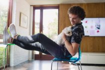 Young man petting dog in home office — Stock Photo