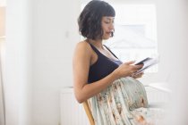 Donna incinta che utilizza lo smartphone — Foto stock