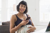Portrait happy pregnant woman using smart phone — Stock Photo
