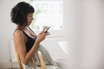 Беременная женщина с помощью смартфона — стоковое фото