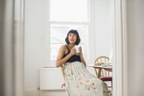 Продумана вагітна жінка п'є чай в квартирі — стокове фото
