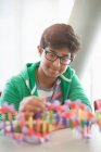Sorridente ragazzo studente assemblaggio DNA modello in aula — Foto stock