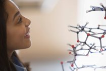 Curious girl student examining molecular structure — Stock Photo