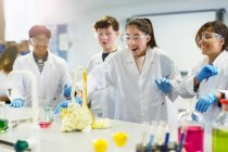 Studenti sorpresi che conducono esperimenti scientifici in schiuma esplosiva in laboratorio in classe — Foto stock