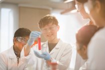 Studenti che esaminano liquido in provetta, conducendo esperimenti scientifici in classe di laboratorio — Foto stock