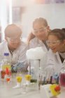 Studenti sorpresi che conducono esperimenti scientifici, guardando la reazione chimica in laboratorio in classe — Foto stock