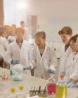 Estudantes surpresos conduzindo experiências científicas de espuma explosiva em laboratório de sala de aula — Fotografia de Stock