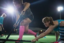 Визначені жінки грають в хокейні палички — стокове фото