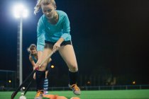 Focalizzato giovane giocatore di hockey su prato femminile praticare esercitazione sportiva sul campo — Foto stock