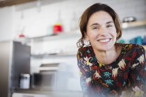 Портрет уверенно улыбающаяся брюнетка женщина на кухне — стоковое фото