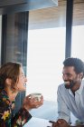 Multi-ethnic couple drinking coffee and talking — Stock Photo